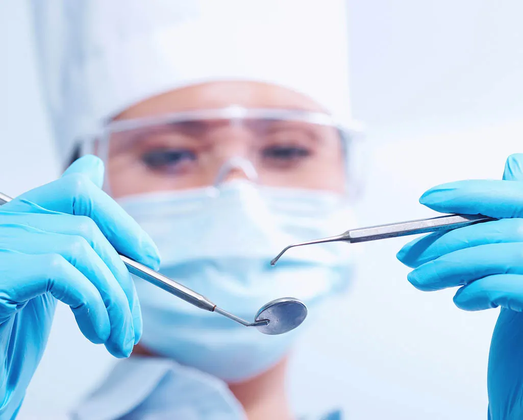 Dentista com instrumentos odontológicos